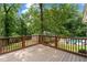 Spacious wooden deck with brown railings overlooks a lush backyard with a pool at 1824 Mount Paran Nw Rd, Atlanta, GA 30327