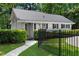 Exterior view of the side of the house featuring a black metal fence, a green lawn and mature trees at 1824 Mount Paran Nw Rd, Atlanta, GA 30327