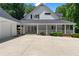 Exterior view of the rear of the house with a large covered porch and a three-car garage at 1824 Mount Paran Nw Rd, Atlanta, GA 30327