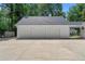 Detached three-car garage with white doors and plenty of parking space on a concrete driveway at 1824 Mount Paran Nw Rd, Atlanta, GA 30327