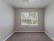 An empty bedroom with gray carpet and a window bringing in natural light at 3458 Carriage Chase Rd, Atlanta, GA 30349