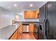 Open concept kitchen with black appliances, wood cabinets, and dark counter tops at 3458 Carriage Chase Rd, Atlanta, GA 30349