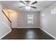 View of the living room with hardwood floors, a ceiling fan, and a staircase at 3458 Carriage Chase Rd, Atlanta, GA 30349