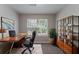 An office space with wood desk, rolling chair, and a full bookshelf at 3458 Carriage Chase Rd, Atlanta, GA 30349
