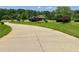 Long driveway leads to a home with well-maintained landscaping and curb appeal at 115 Cannongate Cir, Sharpsburg, GA 30277
