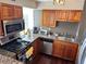 A kitchen features wood cabinets, stainless steel appliances, granite countertops, and natural lighting at 2479 Peachtree Ne Rd # 1714, Atlanta, GA 30305