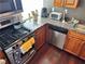 A kitchen features wood cabinets, stainless steel appliances, granite countertops, and dark wood flooring at 2479 Peachtree Ne Rd # 1714, Atlanta, GA 30305