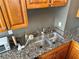 A kitchen features wood cabinets, stainless steel sink, granite countertops, and neutral gray paint at 2479 Peachtree Ne Rd # 1714, Atlanta, GA 30305