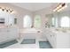 Beautiful bathroom with arched windows, a large soaking tub, white cabinets, and dual vanities at 2693 Blairsden Nw Pl, Kennesaw, GA 30144