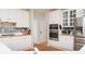 Bright kitchen showcasing updated appliances, white cabinetry, stainless steel double oven, and hardwood floors at 2693 Blairsden Nw Pl, Kennesaw, GA 30144