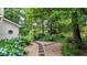 Landscaped backyard featuring a stone walkway surrounded by lush greenery and vibrant blue hydrangea bushes at 4313 Deep Springs Nw Ct, Kennesaw, GA 30144