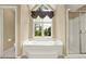 Main bathroom features a soaking tub and window views to the outdoors at 4313 Deep Springs Nw Ct, Kennesaw, GA 30144