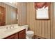 A cozy powder room features vintage wallpaper, a cherry vanity, and natural light at 4313 Deep Springs Nw Ct, Kennesaw, GA 30144