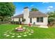 Spacious backyard featuring lush grass, mature trees, and a cozy fire pit area for outdoor entertaining at 910 Laurel Cove Dr, Snellville, GA 30078