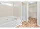 Bathroom features a jetted tub with view of the shower and walk-in closet at 910 Laurel Cove Dr, Snellville, GA 30078