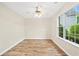 Cozy bedroom featuring hardwood floors, a ceiling fan, and a large window offering backyard views at 910 Laurel Cove Dr, Snellville, GA 30078