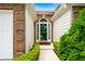 Inviting entryway with a green front door framed by brick and decorative shrubs at 910 Laurel Cove Dr, Snellville, GA 30078
