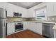 Modern kitchen featuring stainless steel appliances, granite countertops, and white cabinetry at 115 Graystone Terrace Ter, Alpharetta, GA 30005