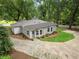 Aerial view of a charming home with lush green landscaping, circular driveway, and guest house at 55 Cooper Lake Rd, Mableton, GA 30126