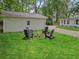 Inviting backyard with a fire pit surrounded by Adirondack chairs, and guest house at 55 Cooper Lake Rd, Mableton, GA 30126