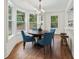 Cozy dining area with a wooden table, elegant blue chairs, and bright windows overlooking the outdoor scenery at 55 Cooper Lake Rd, Mableton, GA 30126