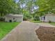 Long driveway leads to a charming home with lush green landscaping and a guest house at 55 Cooper Lake Rd, Mableton, GA 30126