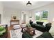Bright living room with an emerald green sofa, lots of natural light and a neutral color palette at 55 Cooper Lake Rd, Mableton, GA 30126