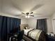 Bedroom with a ceiling fan, blue curtains, and a desk at 726 Shoreline Se Trl, Conyers, GA 30094