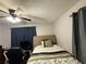 Bedroom with a ceiling fan, blue curtains, and a desk at 726 Shoreline Se Trl, Conyers, GA 30094