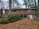 Exterior of the two-story brick home with an upsloping yard and wooden fence at 1917 Penelope Nw Rd, Atlanta, GA 30314
