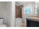 Bathroom with a dark vanity and a shower with earth-toned tile and bright natural light at 2011 Lexington Ave, Atlanta, GA 30344