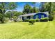 Charming blue home featuring a lush green lawn, mature trees, and manicured shrubs at 2011 Lexington Ave, Atlanta, GA 30344