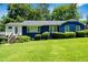 Charming blue home featuring a lush green lawn, manicured shrubs, and inviting front steps at 2011 Lexington Ave, Atlanta, GA 30344