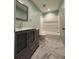 Updated bathroom with marble floors, a shower, and a gray vanity at 6900 Rockland Rd, Stonecrest, GA 30038