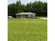 Charming brick home features a sprawling lawn and a backdrop of lush trees at 6900 Rockland Rd, Stonecrest, GA 30038