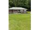 Well-maintained brick ranch with a lush green lawn and mature trees at 6900 Rockland Rd, Stonecrest, GA 30038