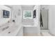 Well-lit bathroom featuring a soaking tub, a shower, and a sink with chrome fixtures at 8320 Mayfern Dr, Fairburn, GA 30213