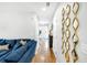 Hallway featuring hardwood floors, modern decor, and blue couch at the end at 8320 Mayfern Dr, Fairburn, GA 30213