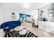 A serene bedroom featuring a plush blue sofa and modern furniture, creating a restful retreat at 8320 Mayfern Dr, Fairburn, GA 30213