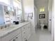 Bright bathroom featuring double vanity with marble countertop, and tiled floors, plus private toilet at 10540 Serenbe Ln, Chattahoochee Hills, GA 30268