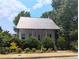 Charming cottage-style home with a metal roof and lush landscaping at 10540 Serenbe Ln, Chattahoochee Hills, GA 30268