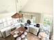 Well-lit kitchen with island and seating, stainless steel appliances, light-colored cabinets, and wood floors at 10540 Serenbe Ln, Chattahoochee Hills, GA 30268