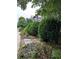 Landscaped front yard featuring well-maintained shrubs and stone pavers leading to the porch at 10540 Serenbe Ln, Chattahoochee Hills, GA 30268