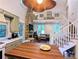 Open concept living area with modern kitchen, stone fireplace, and staircase at 10540 Serenbe Ln, Chattahoochee Hills, GA 30268