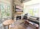 Cozy living room with a stone fireplace and lots of natural light at 10540 Serenbe Ln, Chattahoochee Hills, GA 30268