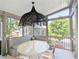 Cozy screened porch with seating, table, overhead lighting, and views of the outside at 10540 Serenbe Ln, Chattahoochee Hills, GA 30268