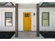 Close up of the front door, painted bright yellow and framed by grey columns at 1071 N Price Rd, Sugar Hill, GA 30518