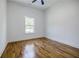 Simple bedroom featuring hardwood floors, white walls, trim, and a window with a leafy view at 115 Dahlia Nw Ave, Atlanta, GA 30314
