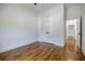 Bedroom featuring hardwood floors, white walls, trim, and views into hallway with white doors at 115 Dahlia Nw Ave, Atlanta, GA 30314