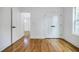 Bedroom with white walls, wooden floors, white doors, and view of hallway with white trim at 115 Dahlia Nw Ave, Atlanta, GA 30314
